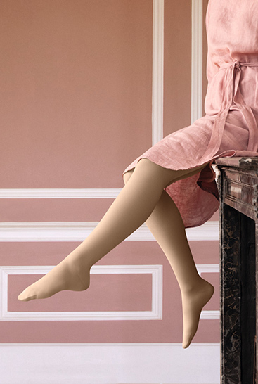 Woman with Juzo Soft Sesame sitting on a mantelpiece