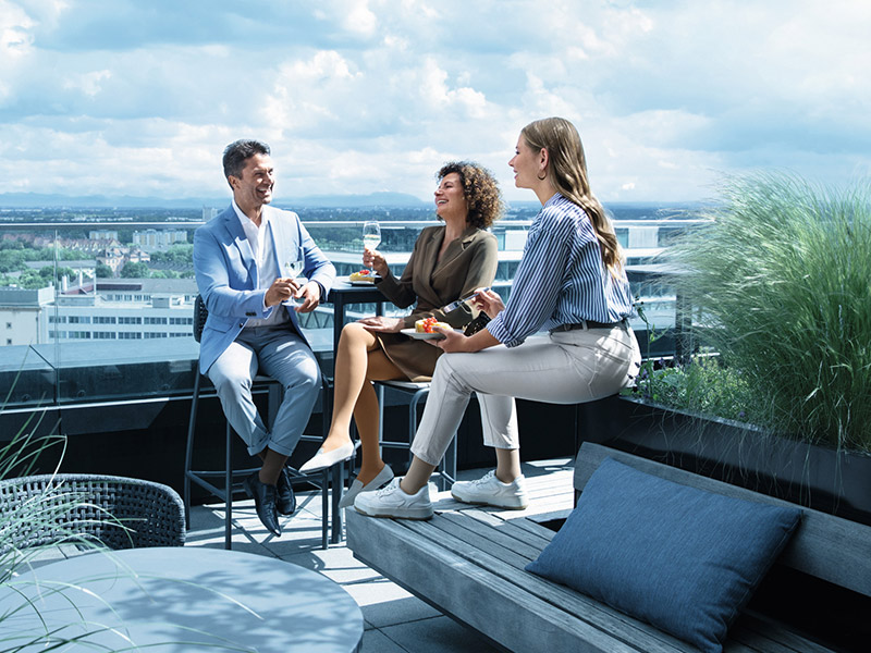 Ein Mann und zwei Frauen mit Kompressionsstrümpfen befinden sich auf einer Dachterasse Ein Mann und zwei Frauen mit Kompressionsstrümpfen befinden sich auf einer Dachterasse