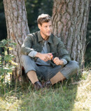 1. Lifestyle image Juzo Adventure Man wearing Juzo Adventure, sitting under a tree and cutting an apple