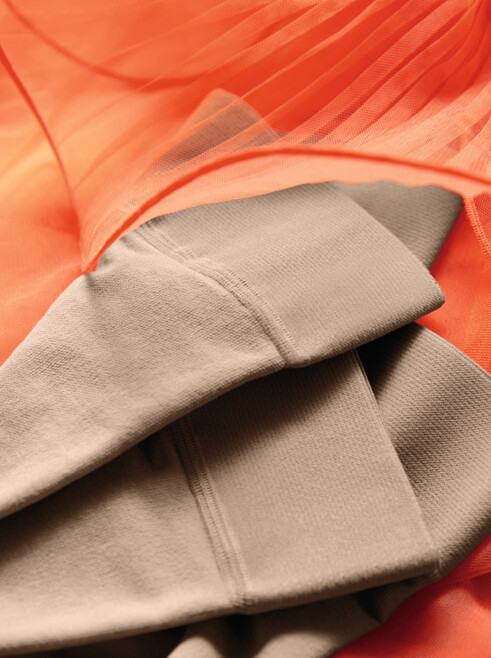 13. Lifestyle Bild Juzo Inspiration Juzo Inspiration Strümpfe liegen auf einem Orangenen Tüllkleid