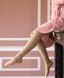 Woman with Juzo Soft Sesame sitting on a mantelpiece