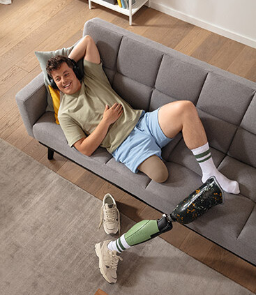 Juzo Classic Seamless bas-moignon de compression Allongé sur le canapé sans son orthèse, un jeune homme porte le bas-moignon de compression Juzo Classic Seamless breveté