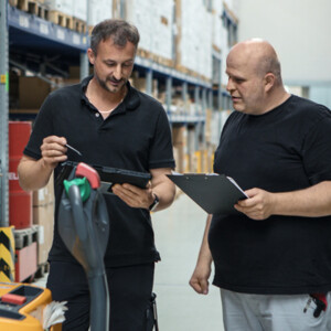 Zwei Männer stehen in einem Logistikzentrum