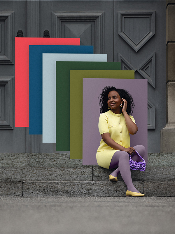 A woman in a yellow dress and purple compression stockings is sitting on a flight of stairs. In the background are blocks of colour in the latest trendy shades