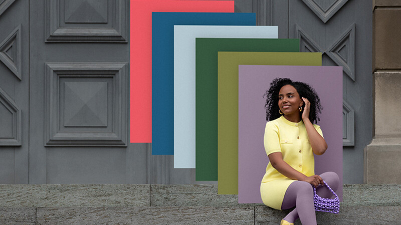 A woman is sitting on a flight of stairs wearing colour-coordinated compression garments; behind her are overlapping patches of colour in various trendy shades.