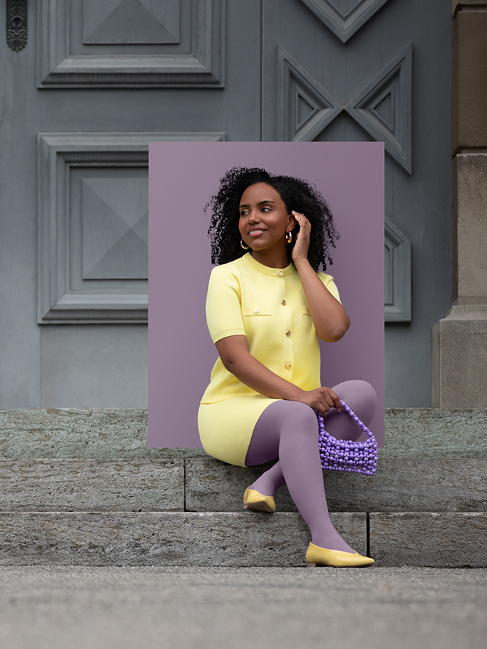 A woman in a yellow two-piece outfit sits on steps wearing a Cosy Violet compression garment